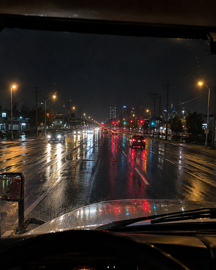 The road ahead at night from a truck cab, seen through treated glass